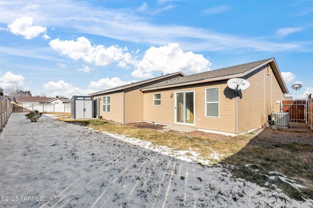 back of house with an outbuilding, a shed, cooling unit, and a fenced backyard