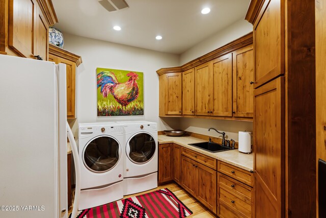 laundry area featuring recessed lighting, a sink, visible vents, cabinet space, and washer and clothes dryer