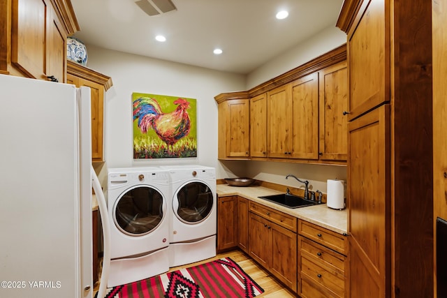laundry area featuring recessed lighting, a sink, visible vents, cabinet space, and washer and clothes dryer