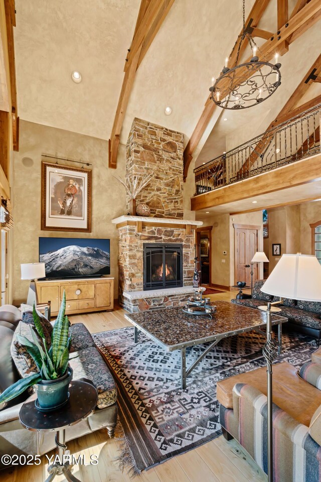 living area featuring a fireplace, a high ceiling, wood finished floors, and beamed ceiling