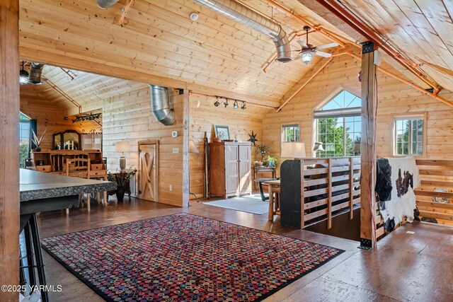 interior space featuring rail lighting, wood ceiling, wood walls, ceiling fan, and high vaulted ceiling