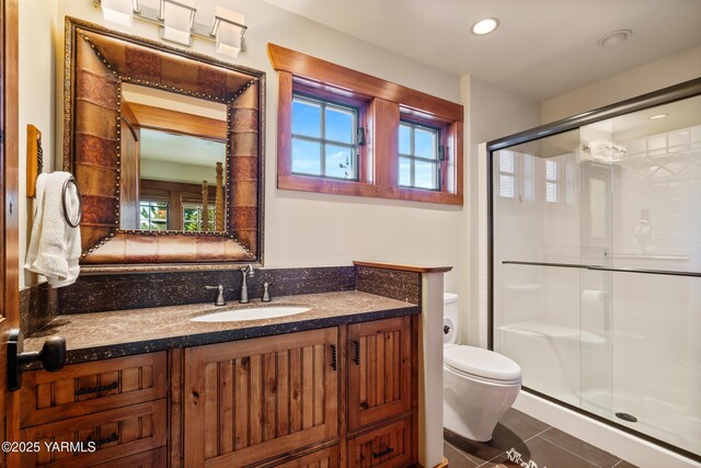 bathroom featuring toilet, a shower stall, tile patterned flooring, and vanity