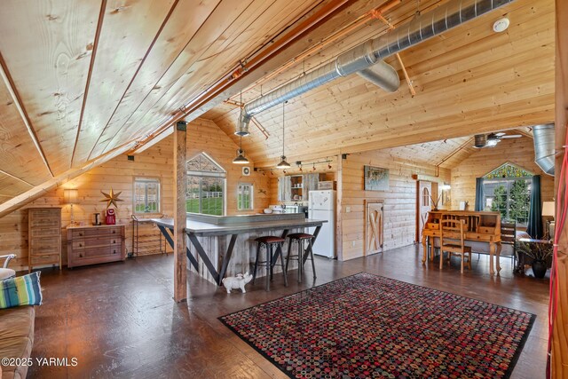 dining room with lofted ceiling, wood walls, wood ceiling, and plenty of natural light