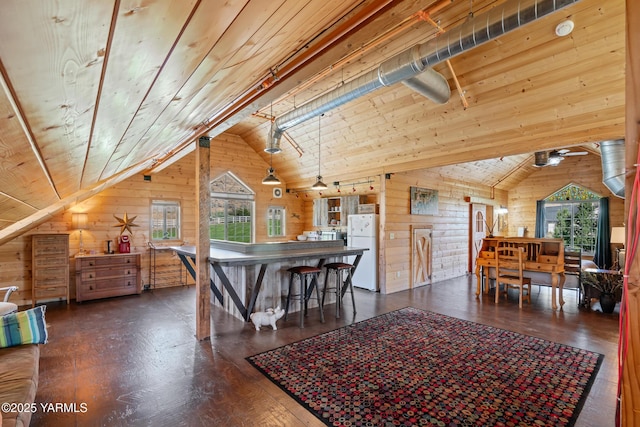 dining room with lofted ceiling, wood walls, wood ceiling, and plenty of natural light