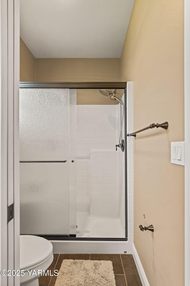 7302 Crown Crest Ave, Yakima, WA 98903 - bathroom featuring tile patterned flooring, toilet, a shower stall, and baseboards