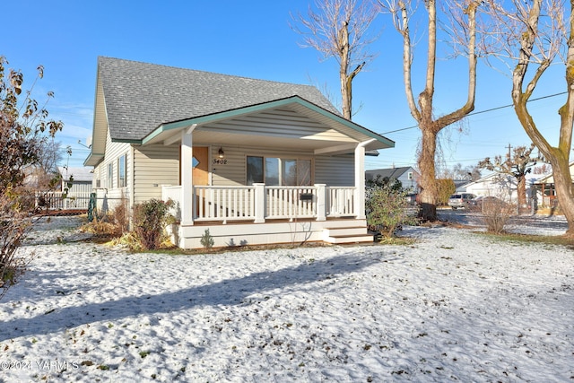 bungalow with a porch and roof with shingles