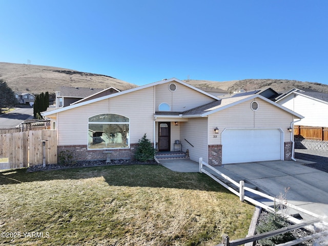 ranch-style home with concrete driveway, an attached garage, fence, a front lawn, and brick siding