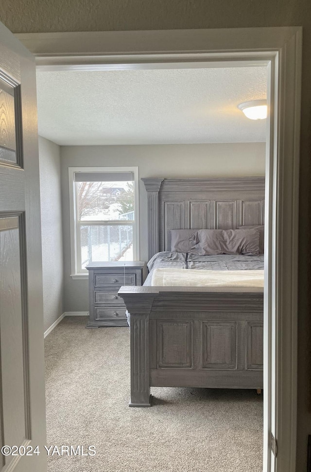 unfurnished bedroom with a textured ceiling, carpet, and baseboards