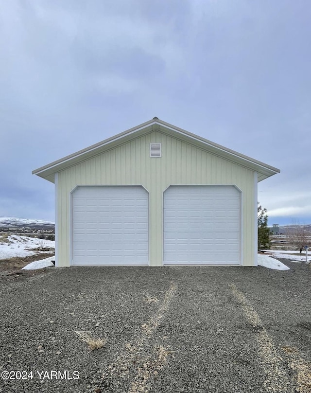 snow covered garage featuring a detached garage