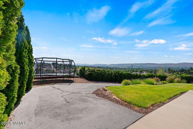 7905 Englewood Ave, Yakima, WA 98908 - view of home's community featuring a mountain view, a lawn, and a trampoline