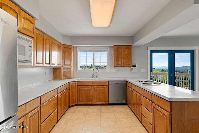 7905 Englewood Ave, Yakima, WA 98908 - kitchen with appliances with stainless steel finishes, a sink, a peninsula, and brown cabinetry