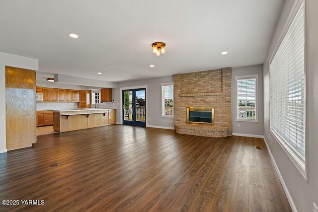 7905 Englewood Ave, Yakima, WA 98908 - unfurnished living room featuring dark wood-type flooring, healthy amount of natural light, baseboards, a fireplace, and recessed lighting