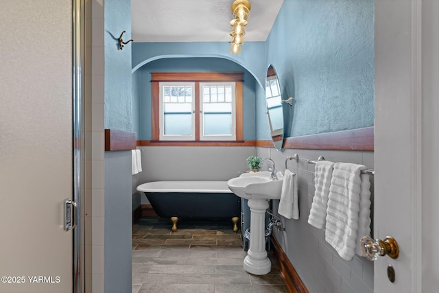 full bathroom with a textured wall, a soaking tub, and a shower with door