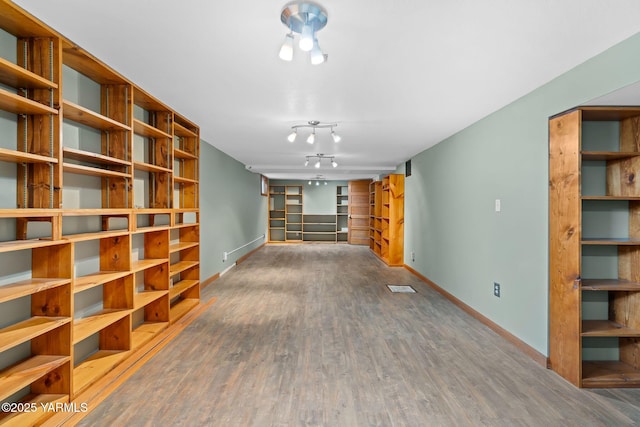 unfurnished living room with wood finished floors and baseboards