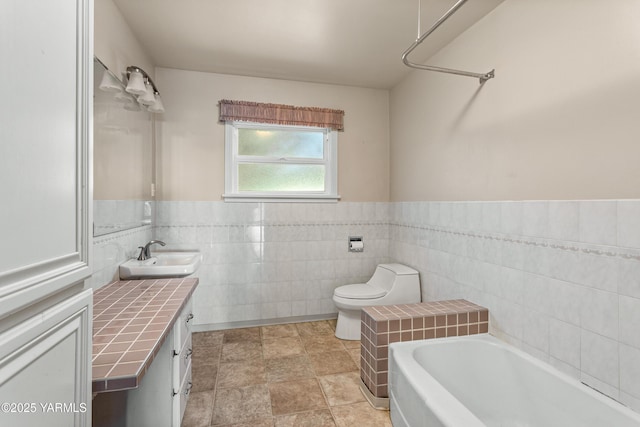 118 Glen Dr, Zillah, WA 98953 - full bathroom featuring vanity, a bath, tile walls, and wainscoting
