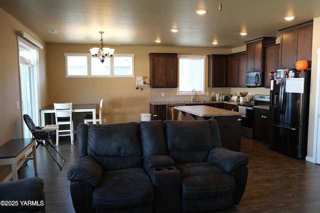 2206 Porter Loop, Yakima, WA 98901 - kitchen featuring appliances with stainless steel finishes, open floor plan, a chandelier, dark brown cabinetry, and recessed lighting
