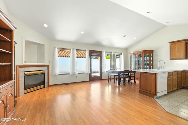 6119 Summitview Ave # 1, Yakima, WA 98908 - kitchen featuring white dishwasher, a peninsula, lofted ceiling, a tile fireplace, and light wood-style flooring