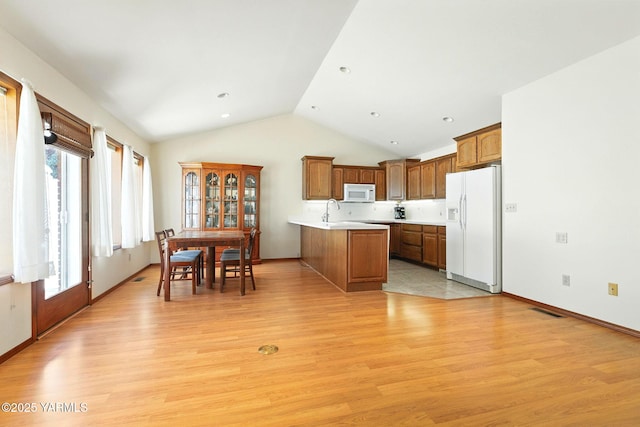 6119 Summitview Ave # 1, Yakima, WA 98908 - kitchen with white appliances, a peninsula, vaulted ceiling, light countertops, and light wood-style floors