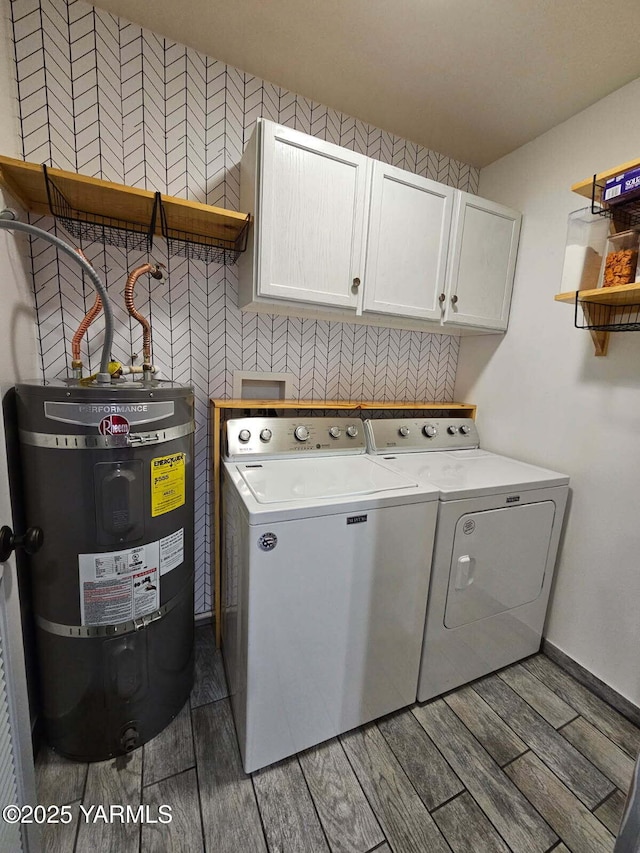 washroom with water heater, cabinet space, wood tiled floor, and washing machine and clothes dryer