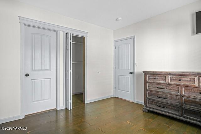 1319 S 15th Ave, Yakima, WA 98902 - unfurnished bedroom featuring dark wood-type flooring, baseboards, and a closet