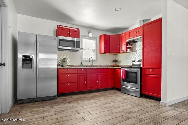 1319 S 15th Ave, Yakima, WA 98902 - kitchen featuring stainless steel appliances, red cabinets, a sink, and light wood-style floors