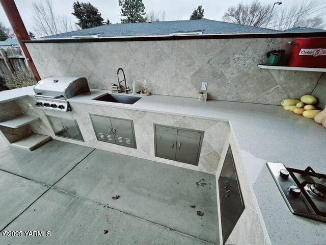 view of patio with grilling area, a sink, and area for grilling