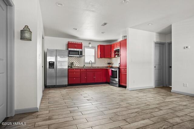 1319 S 15th Ave, Yakima, WA 98902 - kitchen featuring appliances with stainless steel finishes, wood finish floors, a sink, and tasteful backsplash