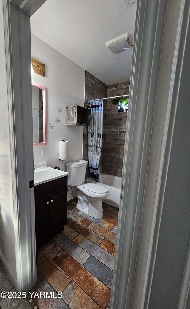 bathroom featuring toilet, shower / bathtub combination with curtain, vanity, and stone tile floors