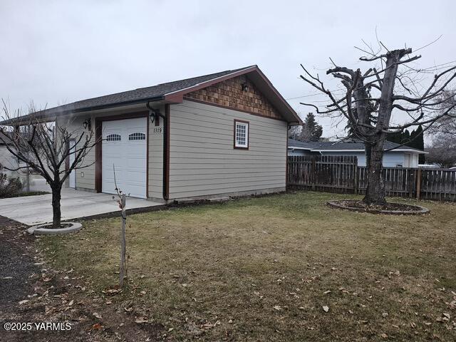 view of outdoor structure featuring a garage and fence