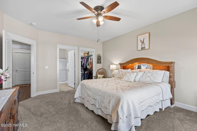 carpeted bedroom featuring a ceiling fan, a spacious closet, baseboards, and a closet