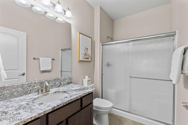 bathroom featuring toilet, a notable chandelier, vanity, a shower stall, and tile patterned floors