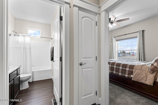 bedroom with ensuite bathroom, dark wood finished floors, and visible vents