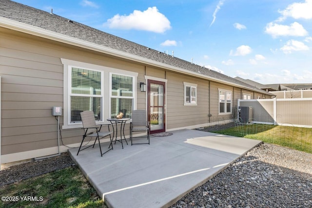 back of house with roof with shingles, fence, cooling unit, and a patio