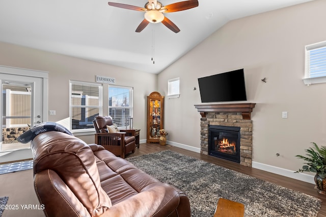 living room with a fireplace, ceiling fan, vaulted ceiling, wood finished floors, and baseboards