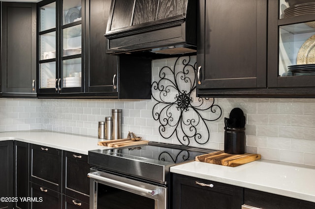1355 Cook Rd, Yakima, WA 98908 - kitchen featuring stainless steel range with electric cooktop, backsplash, glass insert cabinets, and light countertops
