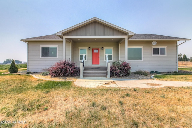 view of front of property featuring covered porch, board and batten siding, and a front yard