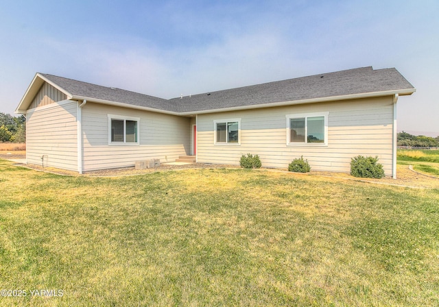 back of property featuring board and batten siding and a yard