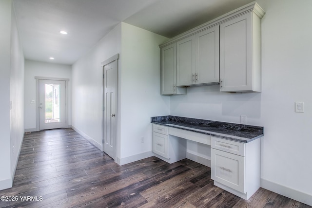 kitchen featuring recessed lighting, baseboards, dark wood finished floors, and built in desk