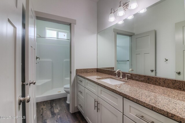 full bathroom with toilet, walk in shower, wood finished floors, and vanity