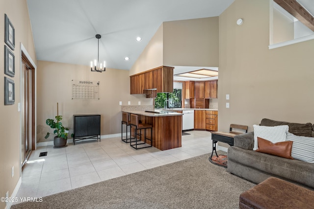 5504 Webster Ave, Yakima, WA 98908 - kitchen featuring open floor plan, white dishwasher, brown cabinets, a peninsula, and high vaulted ceiling