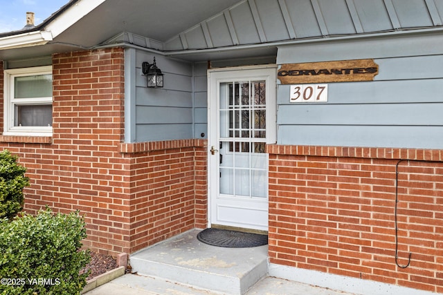 entrance to property featuring brick siding