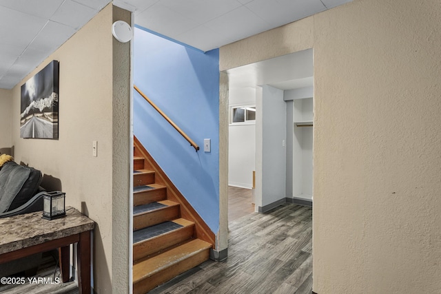 stairs with baseboards, a textured wall, and wood finished floors