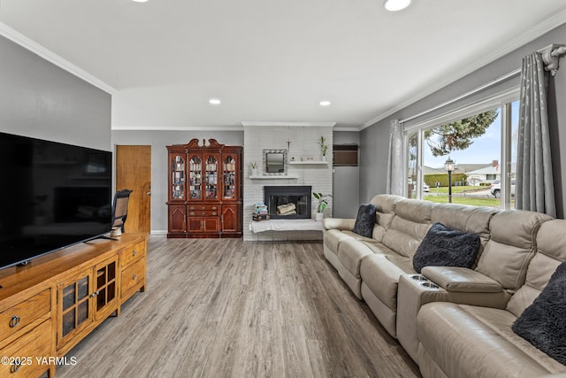 living area featuring crown molding, baseboards, recessed lighting, a fireplace, and wood finished floors