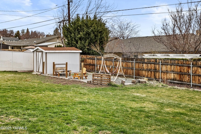 view of yard with an outbuilding, a fenced backyard, and a shed