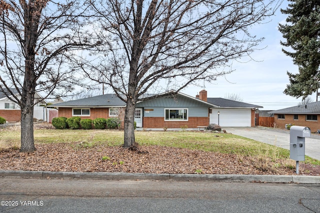 single story home with a front lawn, fence, concrete driveway, an attached garage, and brick siding