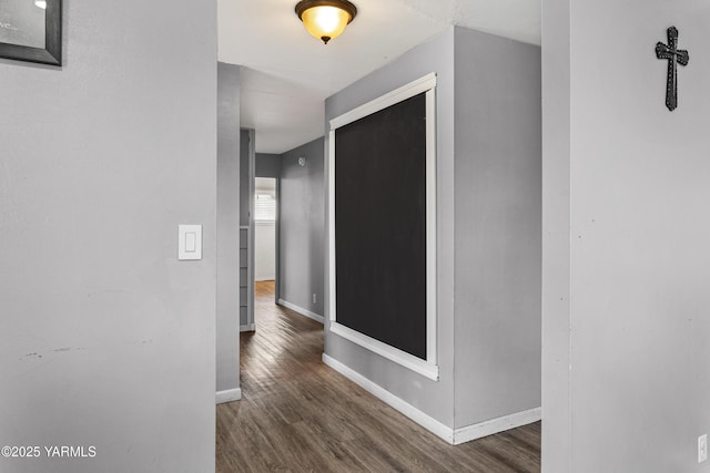 hall featuring baseboards and wood finished floors