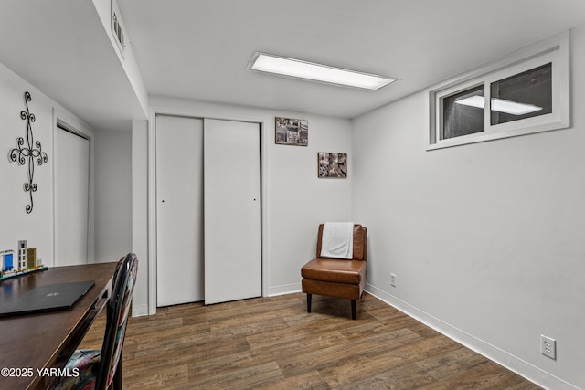 living area featuring visible vents, baseboards, and wood finished floors