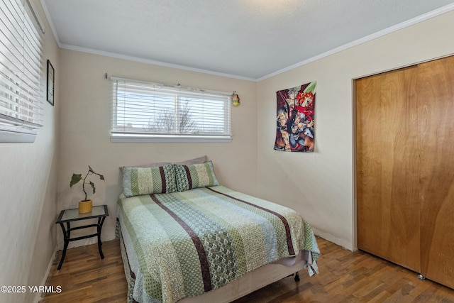 bedroom featuring baseboards, wood finished floors, and ornamental molding