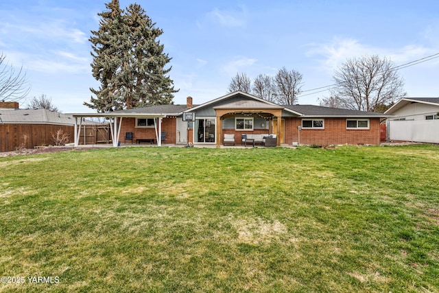 ranch-style house featuring a front yard, a fenced backyard, a patio area, brick siding, and an outdoor hangout area