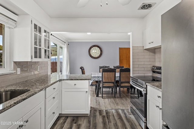kitchen featuring dark wood-style floors, visible vents, stainless steel appliances, white cabinets, and glass insert cabinets